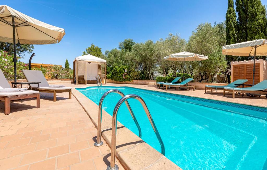a swimming pool with two chairs and umbrellas at Estrella - Son Jorbo in Porreres