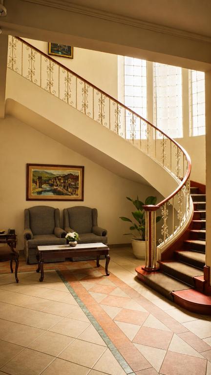 a living room with a couch and a staircase at Hotel Bresciani in La Aurora