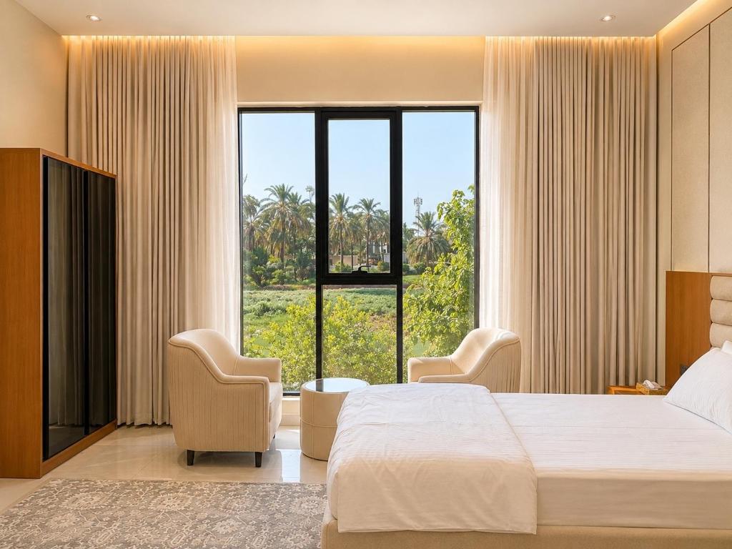a hotel room with a bed and a large window at Al Reef Garden in Sohar