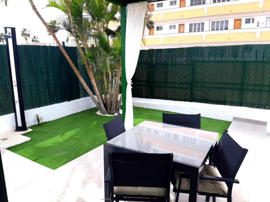 a patio with a table and chairs and a lawn at parking terraza jumbo by stay in gran canaria in Playa del Ingles