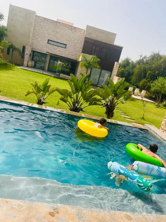 two people are playing in a swimming pool at Villa Terra Akal in Essaouira