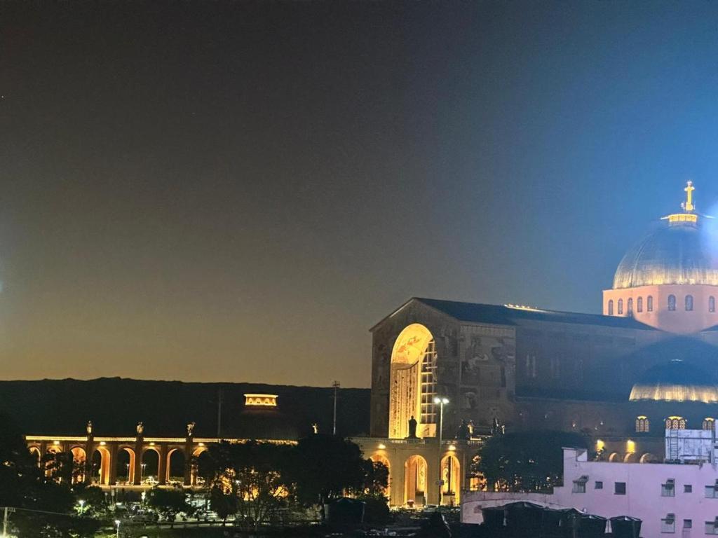 a large building with a dome on top at night at Hotel Akuto's in Aparecida
