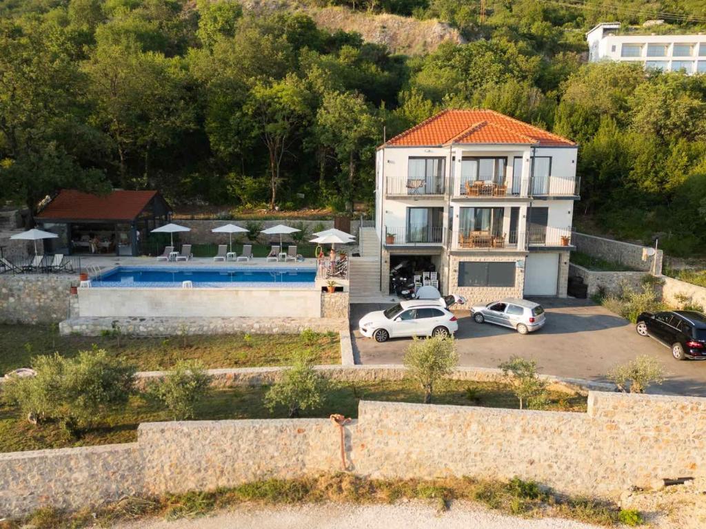 a house with two cars parked in a parking lot at Stanisicguesthouse in Stanišiči