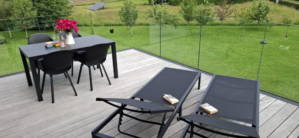 a patio with a table and chairs on a deck at La Terrasse d'Arthur et Manon in La-Roche-en-Ardenne