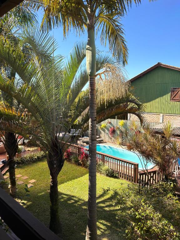 a view of a resort with palm trees and a swimming pool at Studios Malakoopa - Praia do Rosa in Praia do Rosa