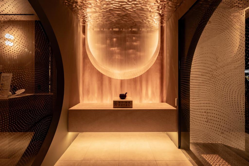 a bathroom with a large light fixture on the wall at My Me Hotel in Seoul