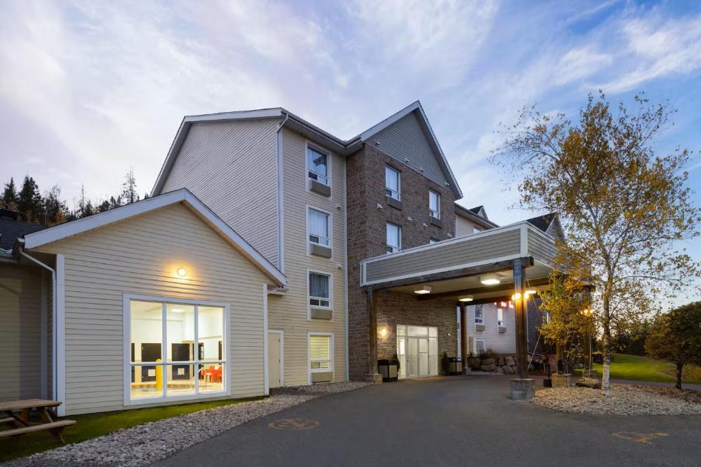 a house with a garage and a building at Hôtel TERRA Laurentides in Sainte-Agathe-des-Monts