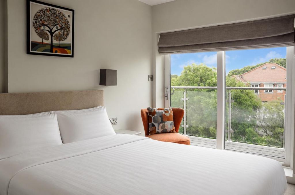 a bedroom with a bed and a chair and a window at Salt Rooms in Scarborough