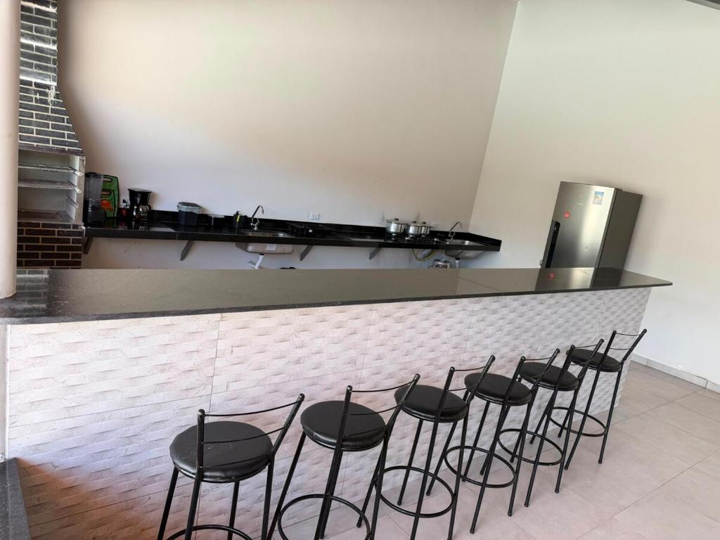 a group of black stools in front of a counter at Casa Dunas douradas in Barreirinhas