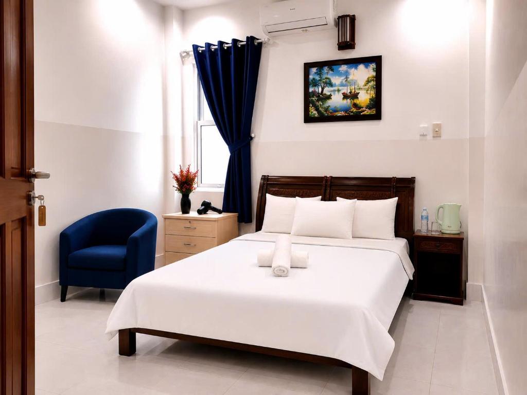 a bedroom with a white bed and a blue chair at SG Cozy2 Hotel - Pham Ngu Lao Street in Ho Chi Minh City