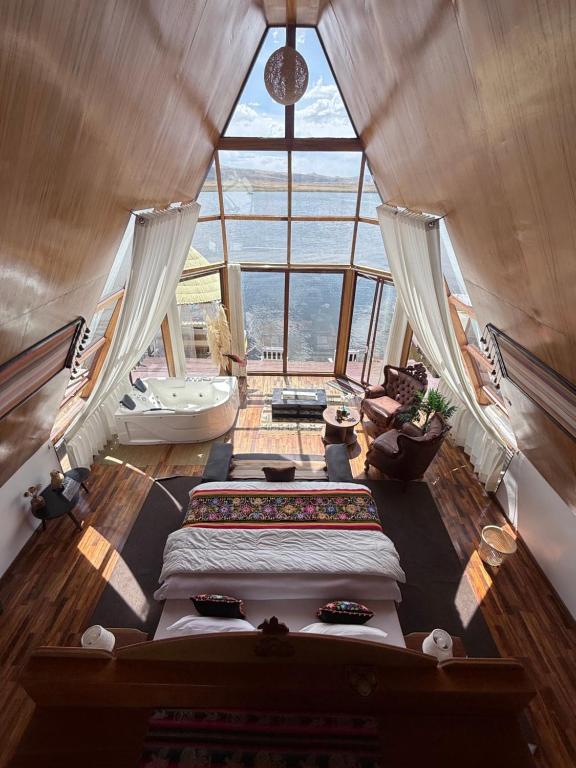 two beds in a room with a large window at TiticacaMarkaLodge in Puno