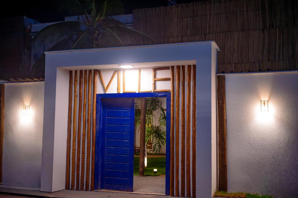 a blue door leading into a house at night at Pousada Ville Solare Garden in Santo Amaro