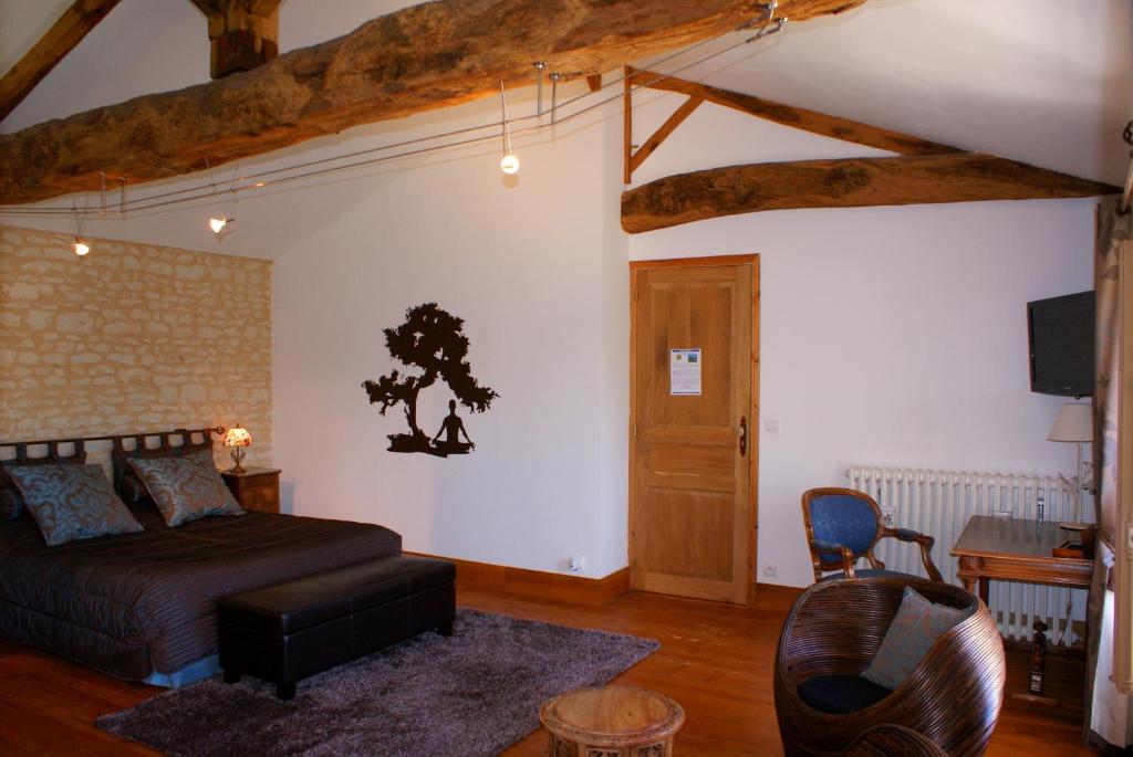 a bedroom with a bed and a table and a chair at Le Domaine des Doucins & Spa, Gîte 4 étoiles, 10 minutes de Jonzac piscine et spa in Fontaines-dʼOzillac