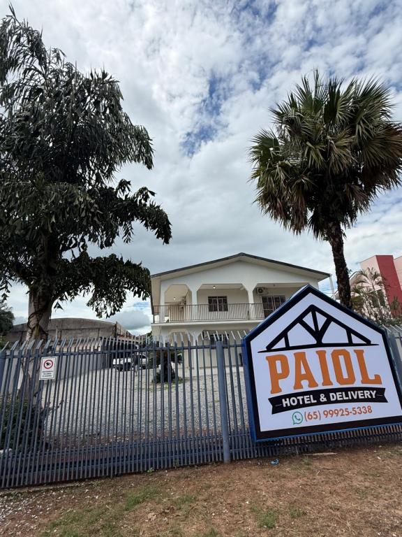 a sign on a fence in front of a house at hotel paiol mutum in Nova Mutum