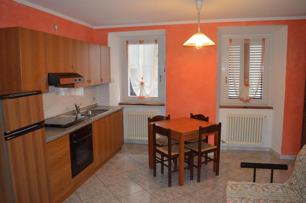 eine Küche mit einem Holztisch und einem Esszimmer in der Unterkunft Residence Arvinei in Malesco