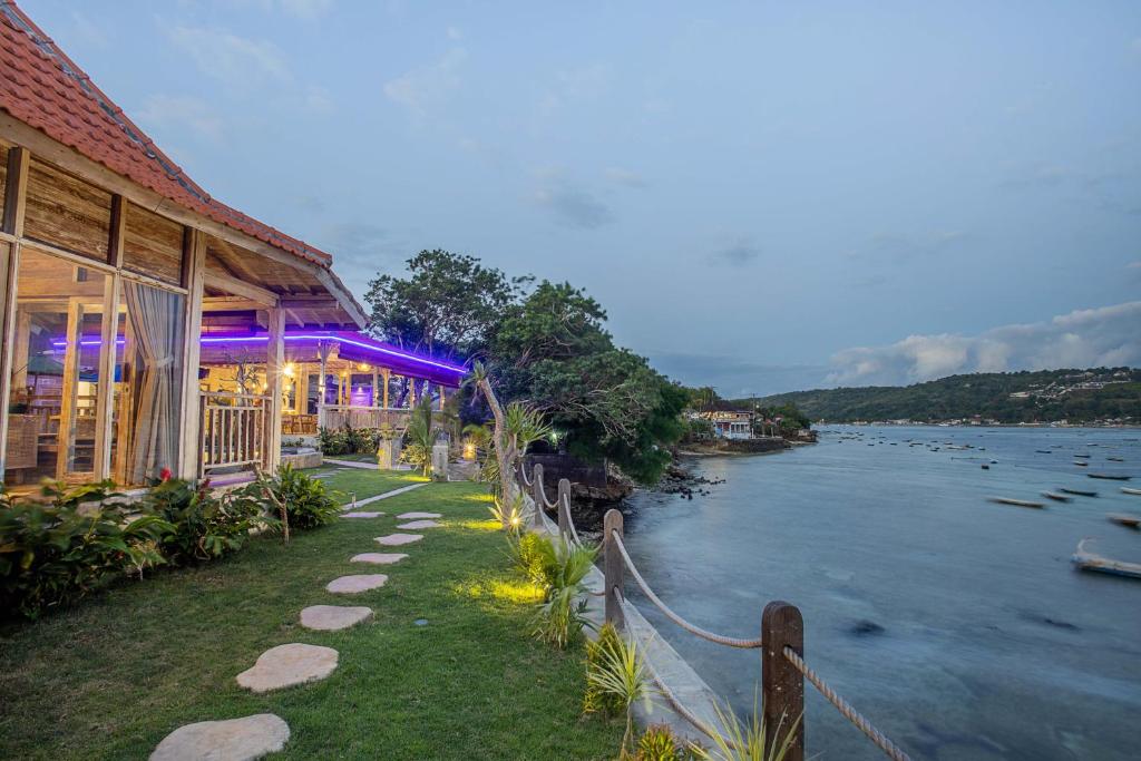 a building next to a body of water at The Old Island Huts in Nusa Lembongan