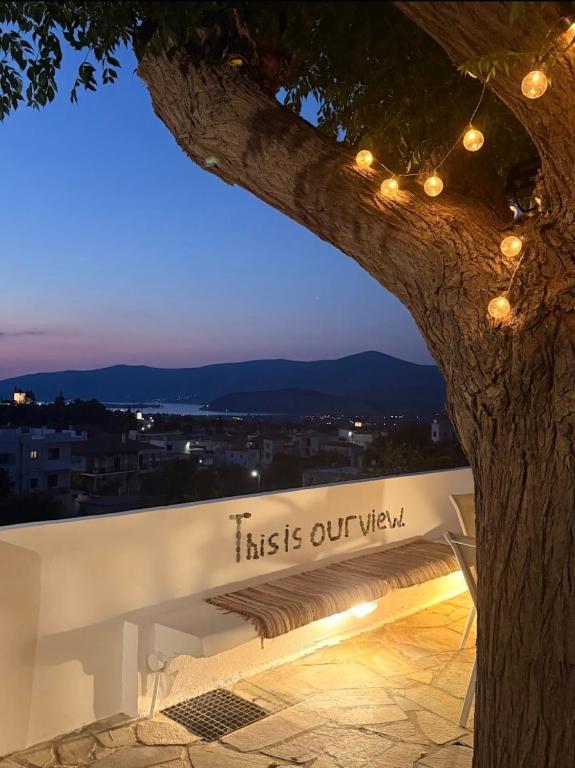 a bench with a sign that reads this is our view at Agia Anna Horizon in Kranidi