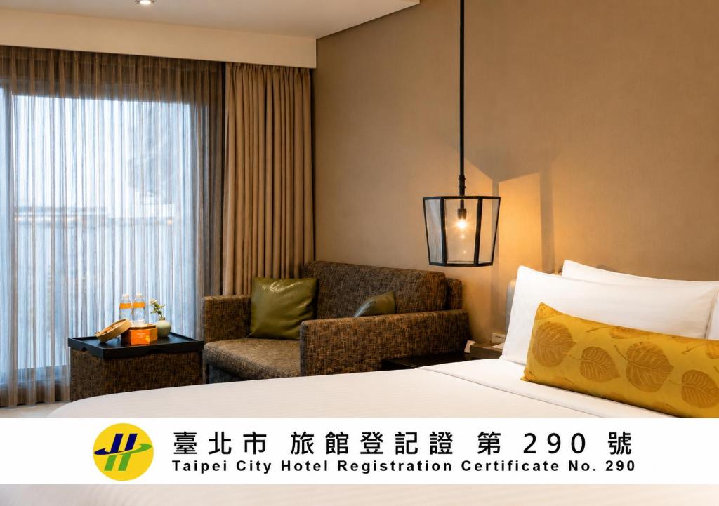 a hotel room with a bed and a chair at Pacific Business Hotel in Taipei