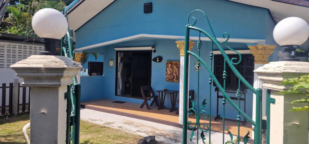 ein blaues Haus mit einer Veranda und einem Tisch in der Unterkunft Ryans Resort in Prasat