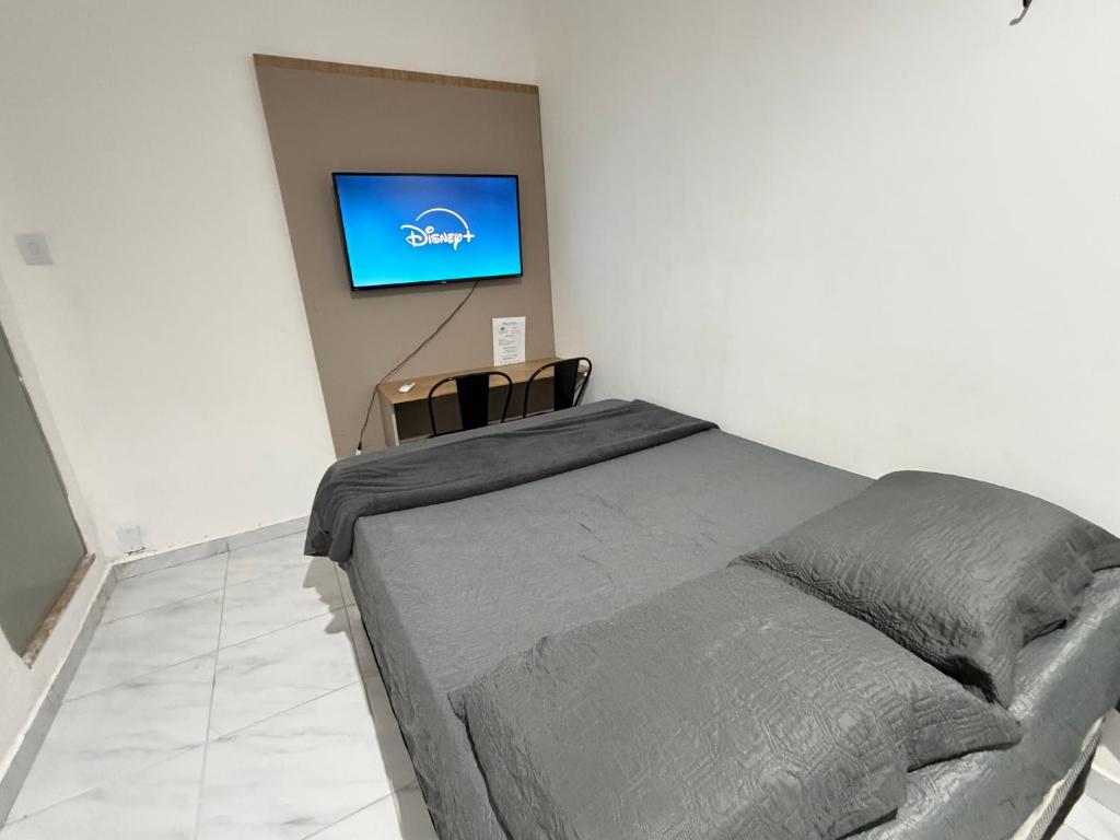 a bedroom with a bed and a tv on a wall at Ap em bairro nobre com garagem e ar in Sobral
