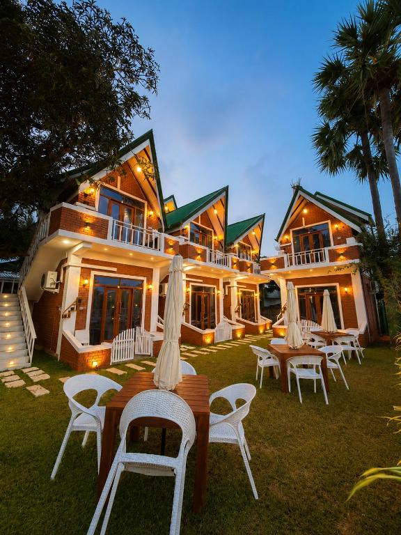 a group of tables and chairs in front of a building at The Oshin Villa in Trincomalee