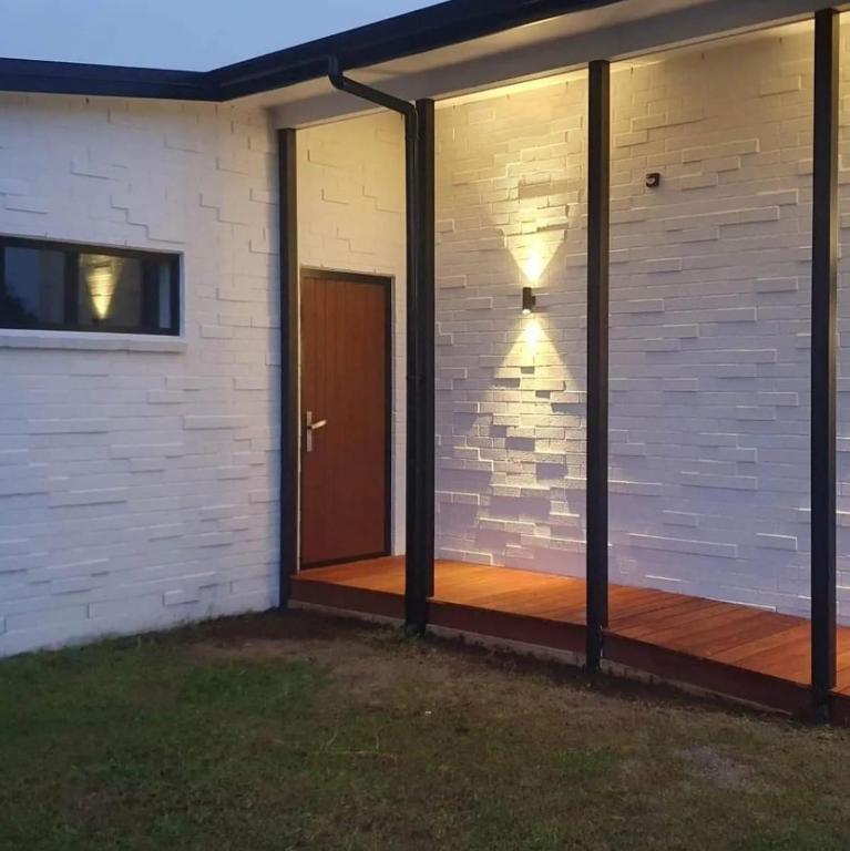 a screened in porch with a door and a brick wall at Stylish townhouse in Te Aroha