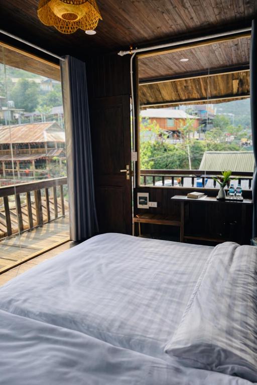 a bedroom with a bed and a large window at Ơ MÂY ZING Homestay in Bắc Yên
