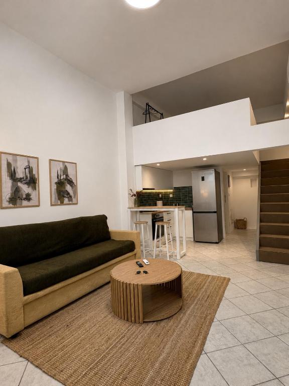 a living room with a couch and a table at Tailor Urban Loft Thiva in Thiva