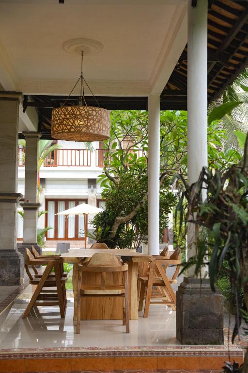 a wooden table and chairs on a patio at Umanara Ubud in Ubud