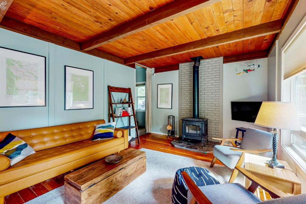 a living room with a couch and a fireplace at Wooded-View Decks: Family Cabin Retreat in Deming in Warnick