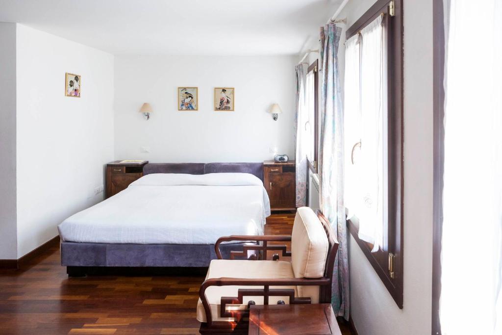 ヴェネツィアにあるFujiyama B & Bのベッドルーム1室(ベッド1台、椅子、窓付)