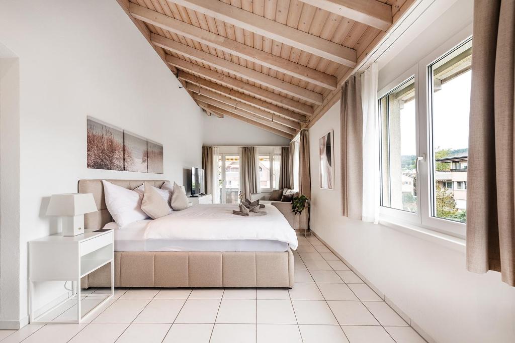 a bedroom with a large bed and large windows at COZY 3 !Gratis Parken, Free Parking! in Weinfelden
