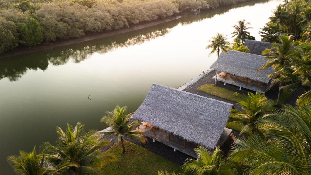 an aerial view of a resort with palm trees and water at Cay's House Batukaras in Batukaras