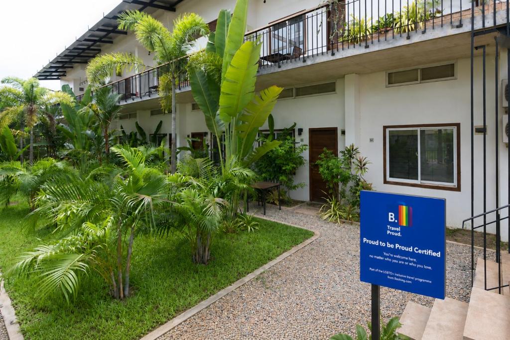 a sign in front of a building with plants at Phan NaTa Apartment in Siem Reap