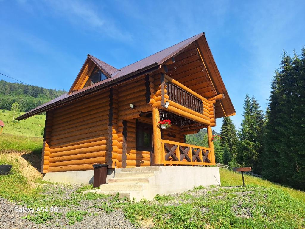 a log cabin with a staircase leading to the front door at Шепіт Карпат 2 in Synevyrsʼka Polyana