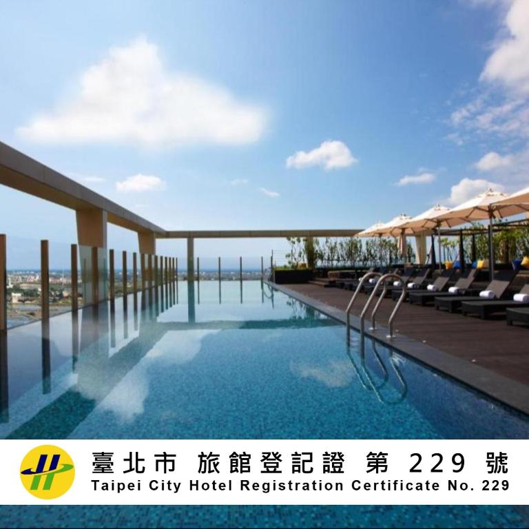 a hotel swimming pool with chairs and umbrellas at Wellspring by Silks Jiaoxi in Jiaoxi
