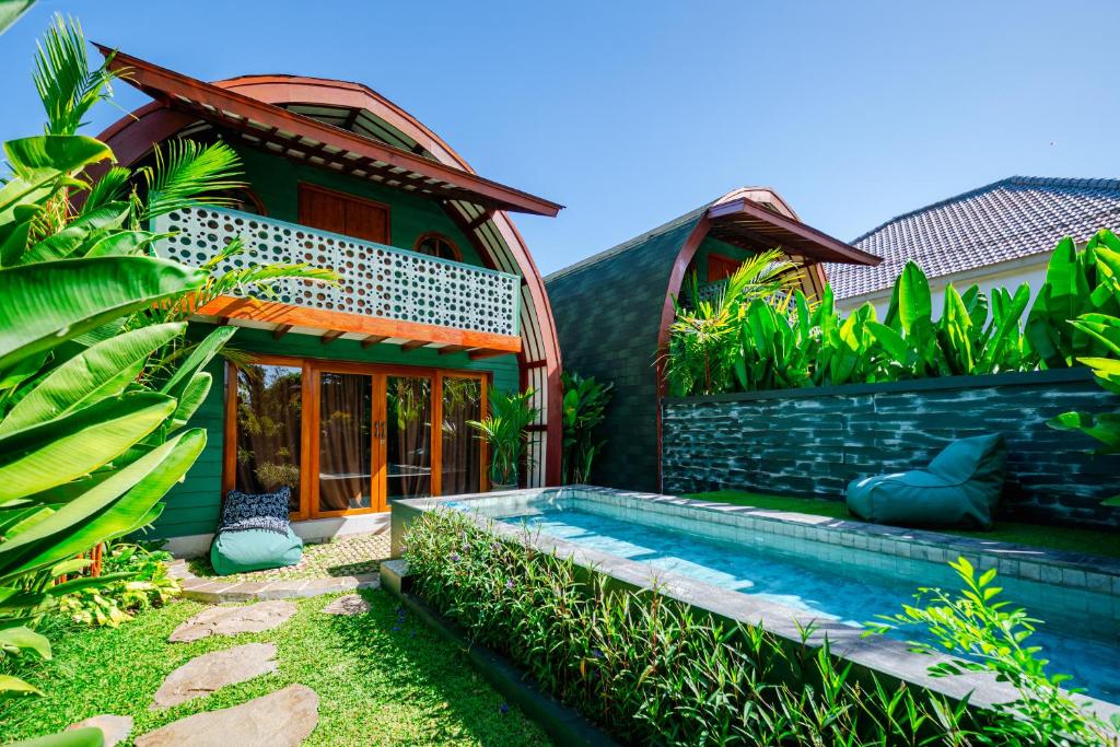 a house with a swimming pool in front of it at Eywa Retreat in Uluwatu