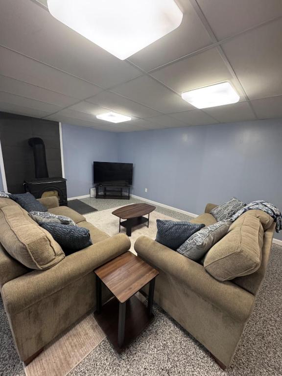 a living room with two couches and a flat screen tv at House in Hannibal in Hannibal