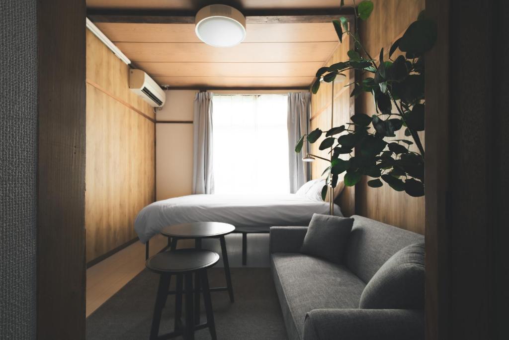 a room with two beds and a couch and a table at Sand Village Kikuna in Kikuna