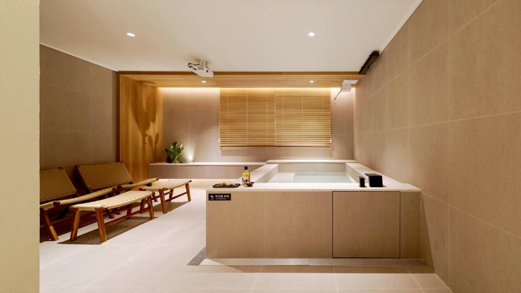 a kitchen with a tub and a table and chairs at Anook Hotel Busan Gwangalli in Busan