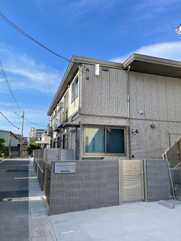 a building with a fence in front of it at House Nozomi in Kyoto