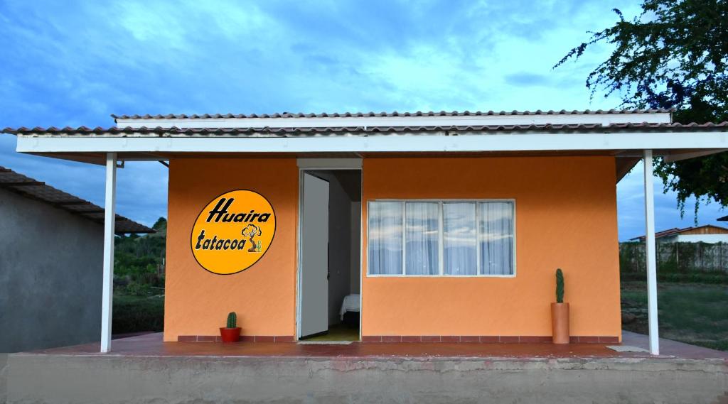 a small orange building with a sign on it at HUAIRA Tatacoa in Villavieja