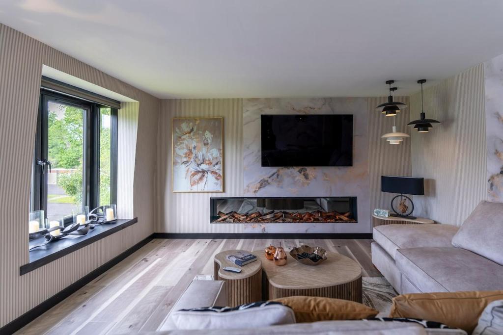 a living room with a couch and a fireplace at Gleneagles Village Penthouse in Tullibardine Station