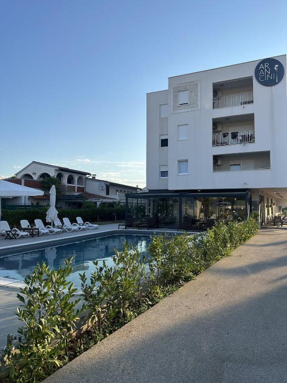 a building with a swimming pool in front of a building at Aurum Apartmanı in Vodice