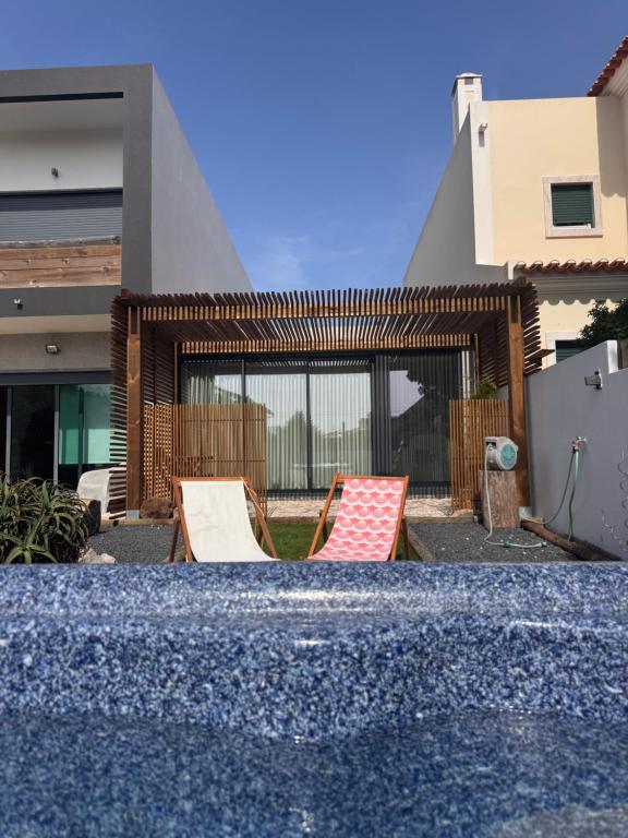 a group of chairs sitting in the backyard of a house at Nortada in Alcabideche