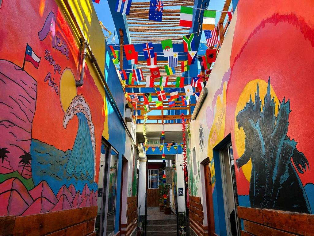 an alley with colorful walls and ceilings with flags at Raymi House Hostel in Arica