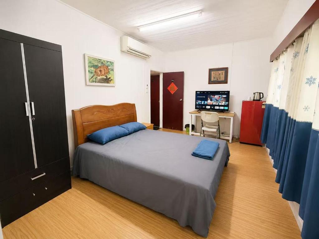 a bedroom with a bed and a desk with a computer at Comfortable Ensuite Room in Suva CBD in Suva