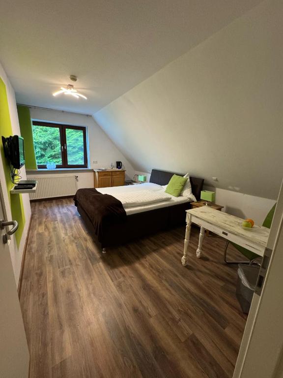 a bedroom with a bed and a table in it at ManusFaktur Waldcafé und Hotel in Nordhastedt