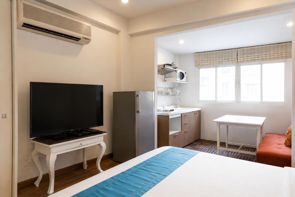 a small room with a bed and a television at Suk41 Bangkok Hotel in Bangkok