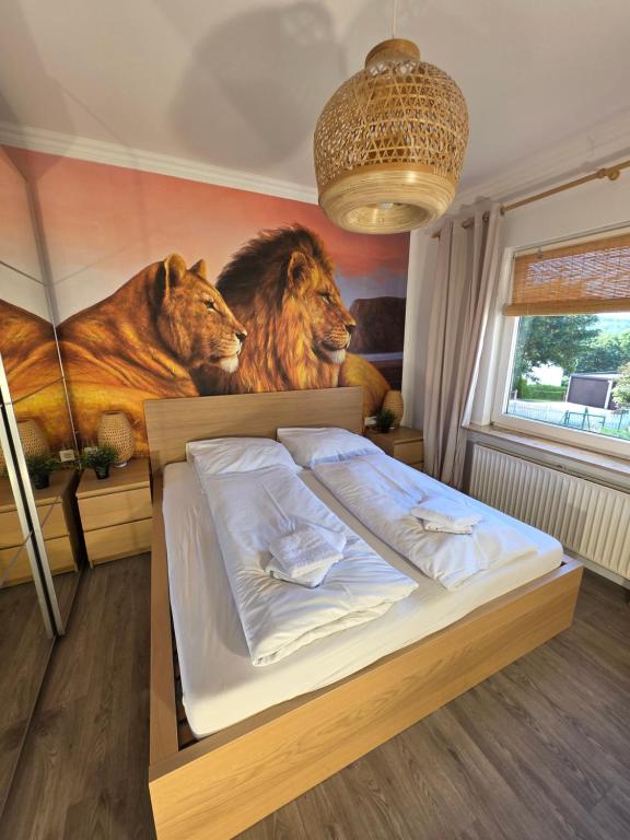 a bedroom with a mural of lions on the wall at Ferienhaus Löwe in Niedenstein